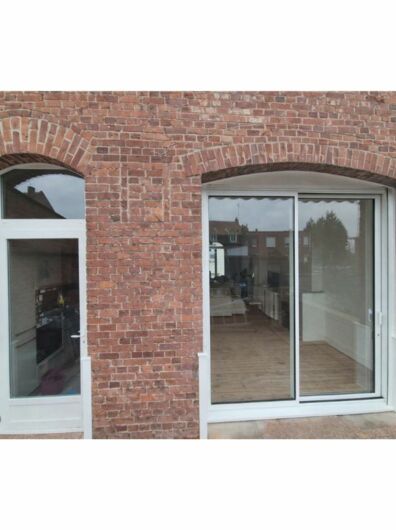 Baie coulissante aluminium à rupture de pont thermique et porte de service PVC